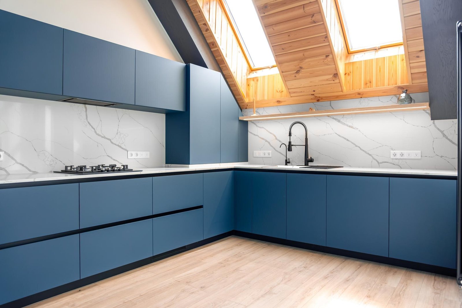 Modern matte blue sprayed kitchen with marble worktop and skylights